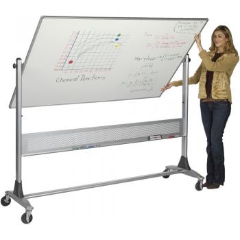 A teacher stands beside a standing dry erase board.