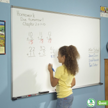 A child works math problems on the magnetic dry erase classroom whiteboard with aluminum frame.