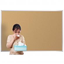 A woman is shown standing in front of a standard cork board with a box of tissues.