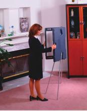 A lady is unfolding a portable presentation whiteboard.