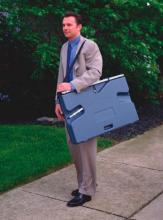 A man is carrying a portable presentation whiteboard.