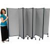 A lady stands beside room divider panels.