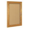 An oak framed enclosed cork board is shown with acrylic cover/